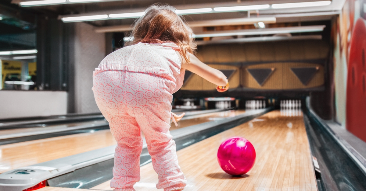 girl carrying red bowling ball