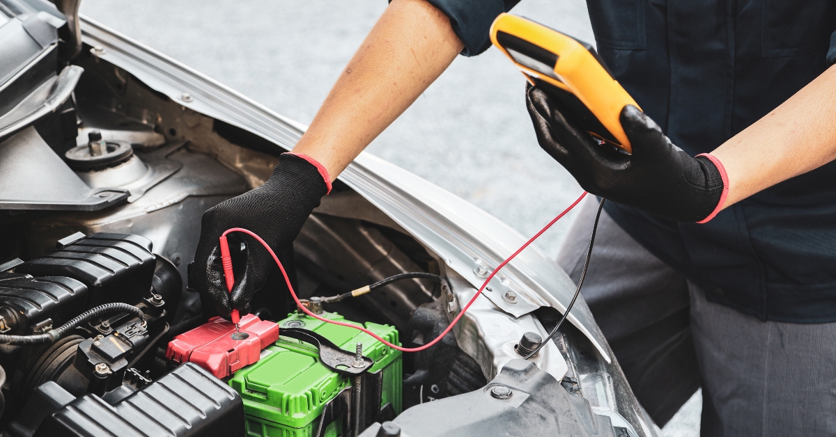 car mechanic use voltmeter