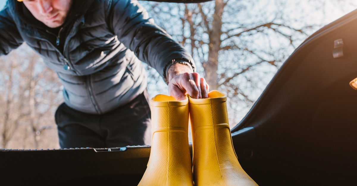 man loads yellow rubber boots