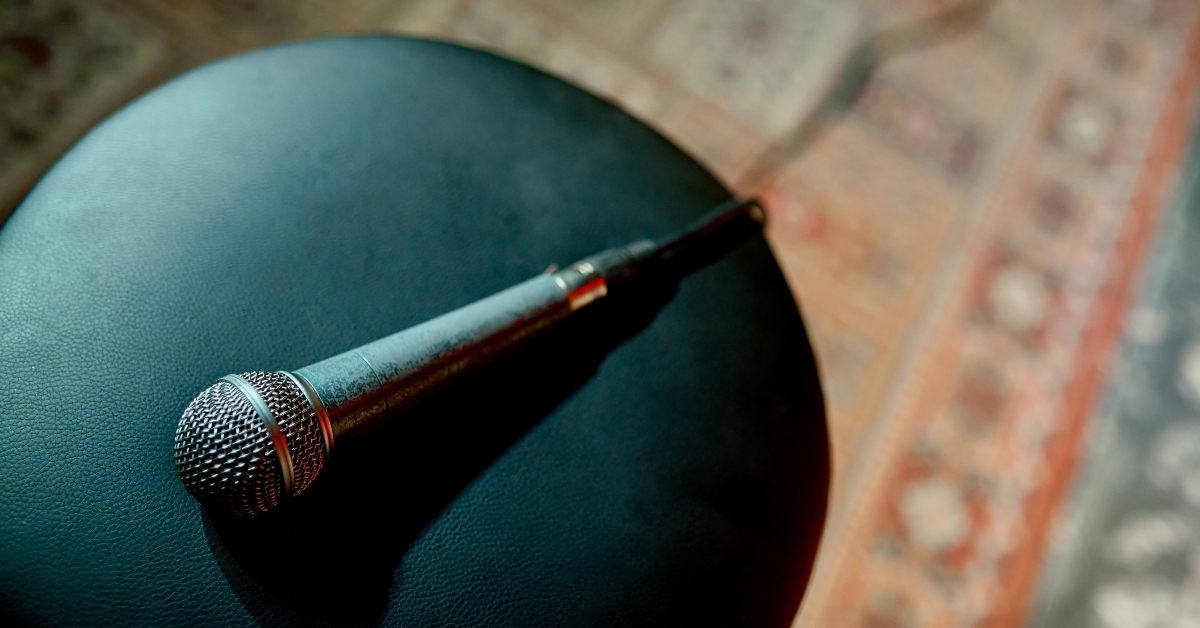 A wired scuffed microphone lies