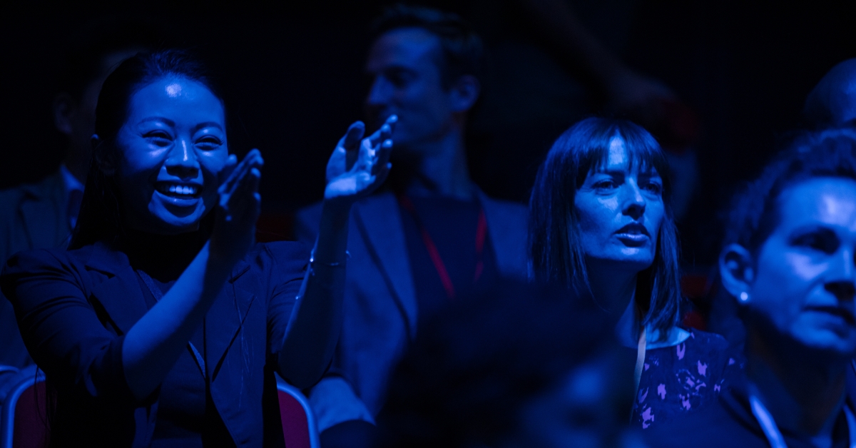Enthusiastic audience in dark auditorium