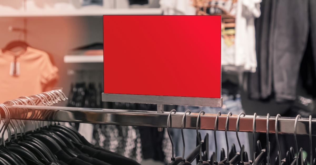 Red colored price poster on clothes rack