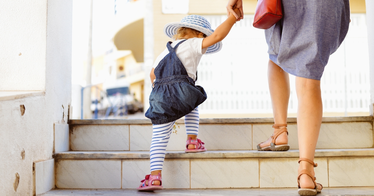 Toddler girl walking with mother