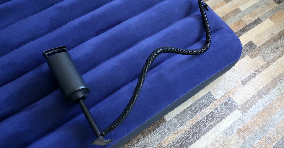 inflatable mattress and foot pumper on floor