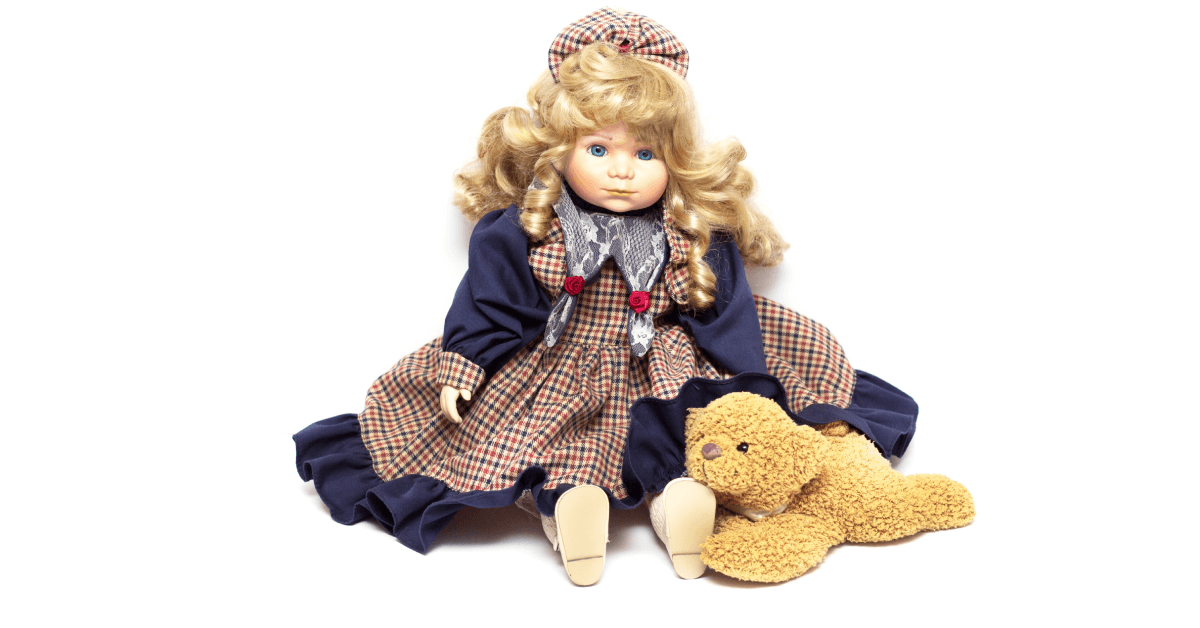 Old porcelain doll and a teddy bear.