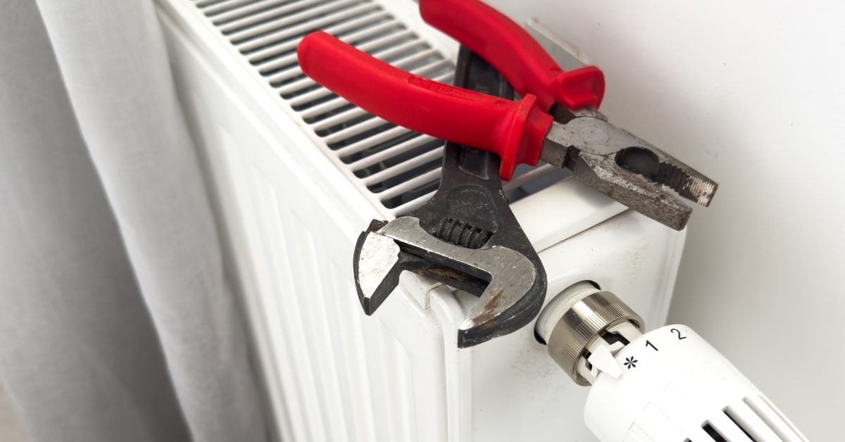 wrench over radiator man installing radiator valve
