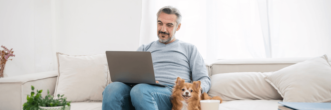 person on laptop with dog