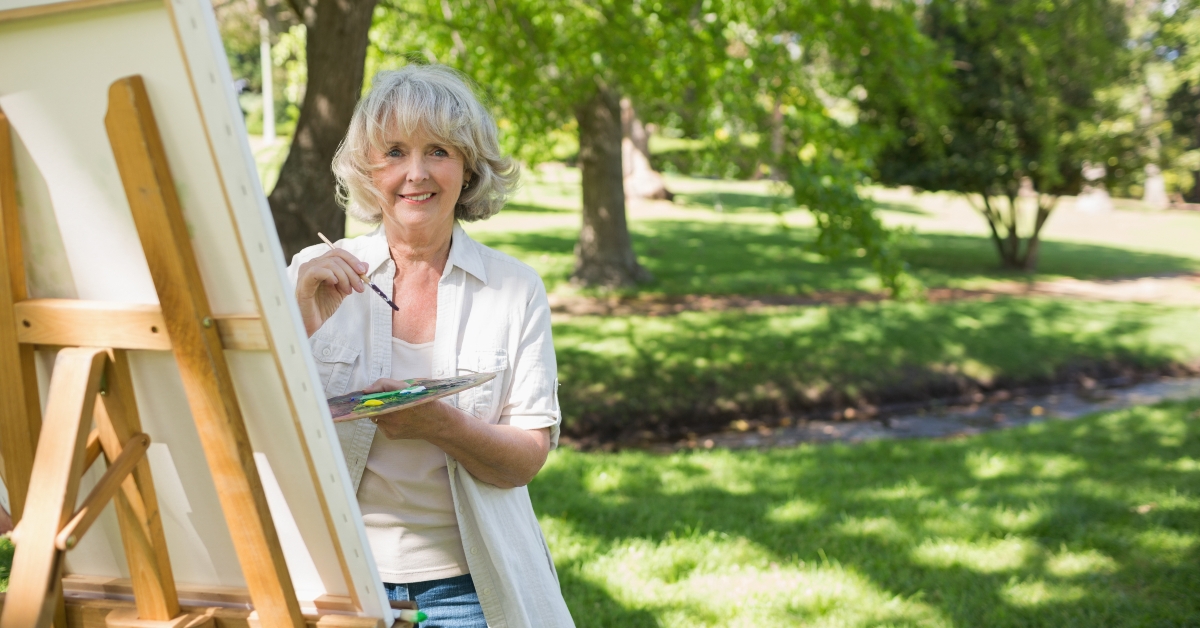 Smiling mature woman painting