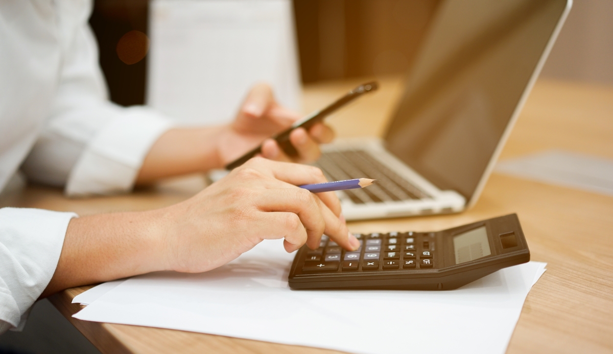 Man hand pressing on calculator