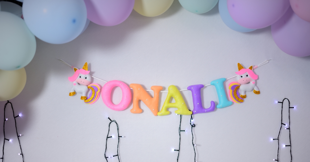 name banner and pastel colored balloon