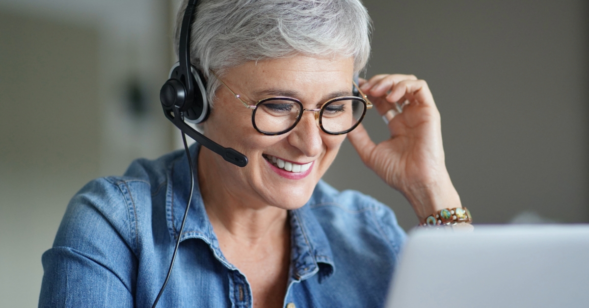 Mature woman with gray, short hair working from home during pandemic