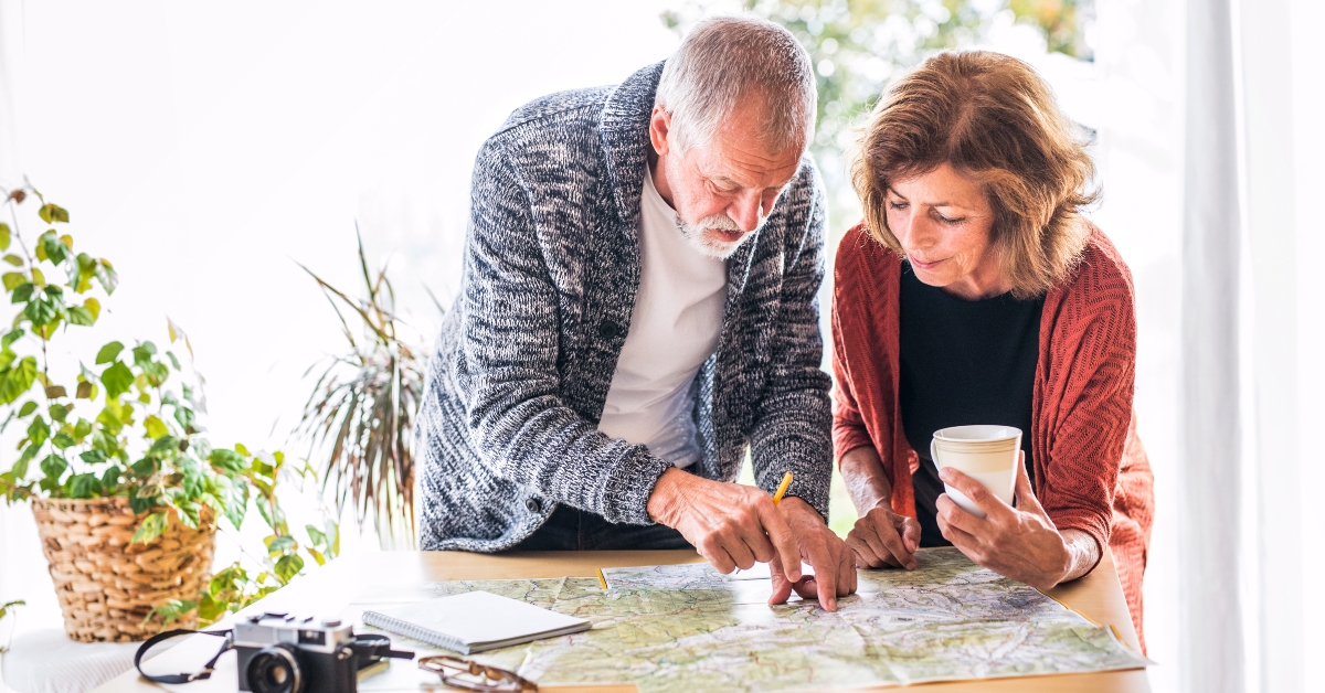 Senior couple with map at home, making plans