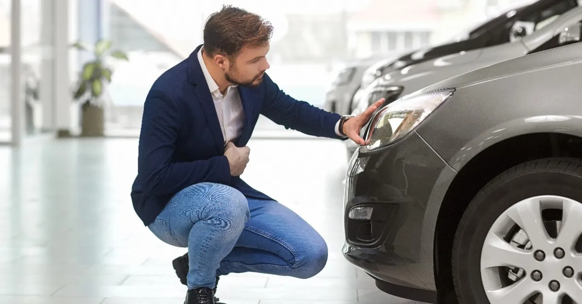 man thinks in the car dealership