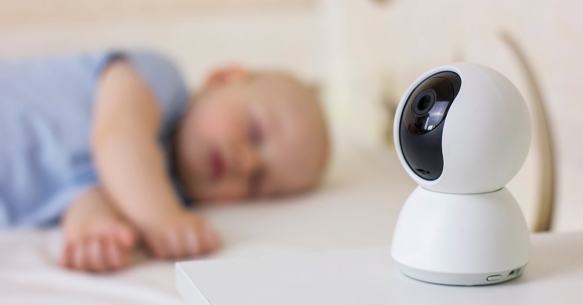 baby boy sleeping on bed at home with baby monitor camera