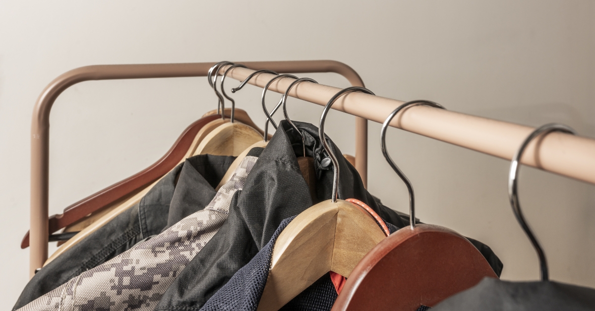 metal rack filled with hangers of men's clothing