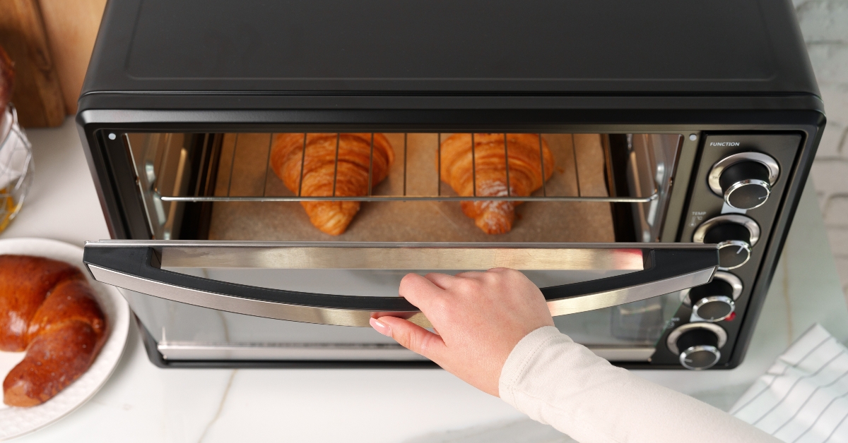 Female hand taking delicious croissants