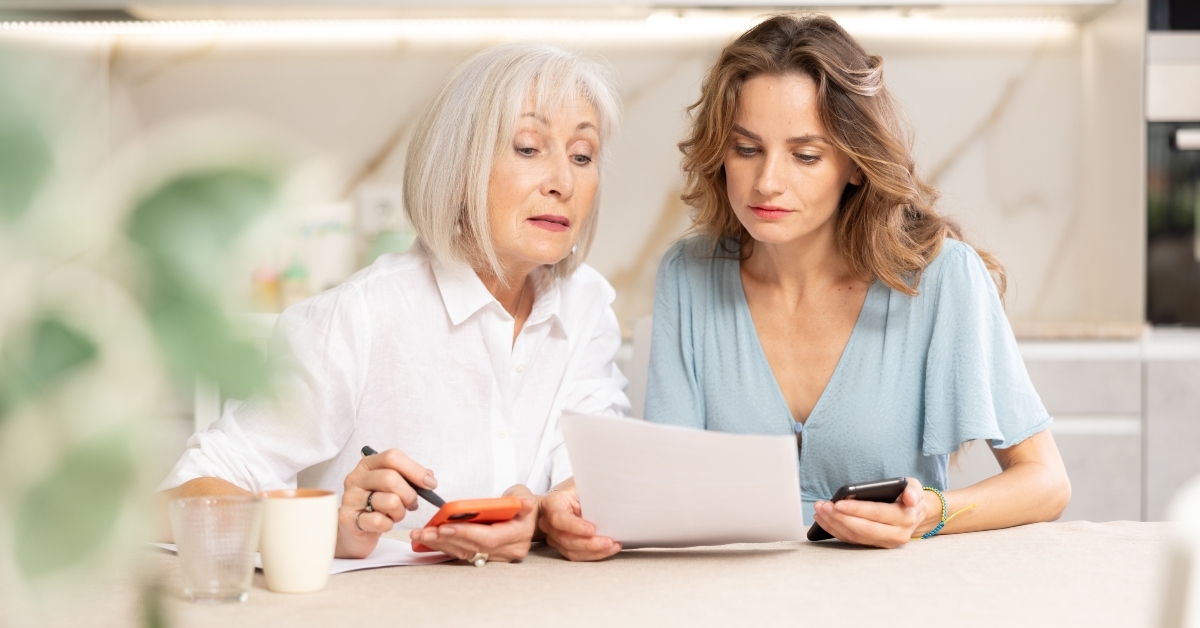mother and daughter sitting at table and calculating finances
