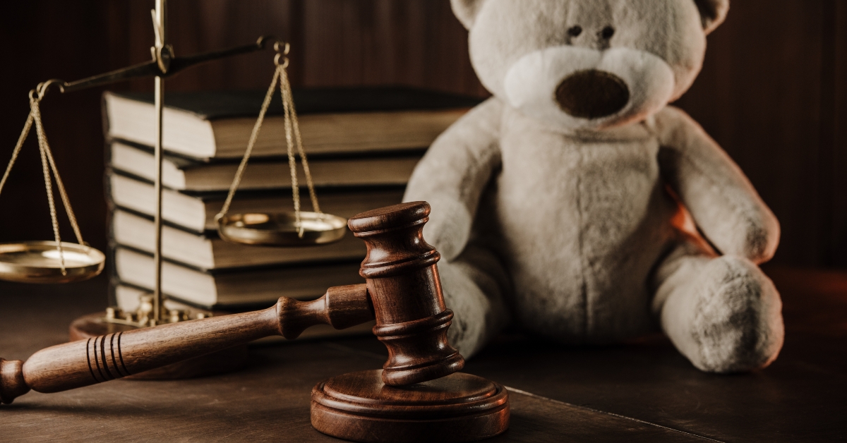 Wooden gavel and teddy bear symbol of child on a desk