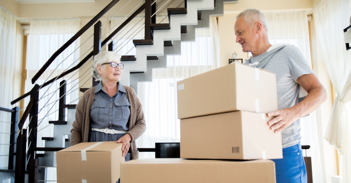 portrait of happy senior couple packing cardboard