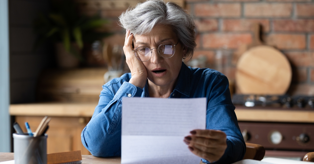 Unhappy mature wearing glasses reading bad news