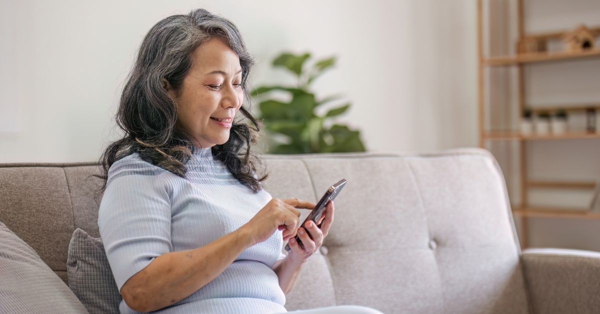 woman using her phone on a sofa