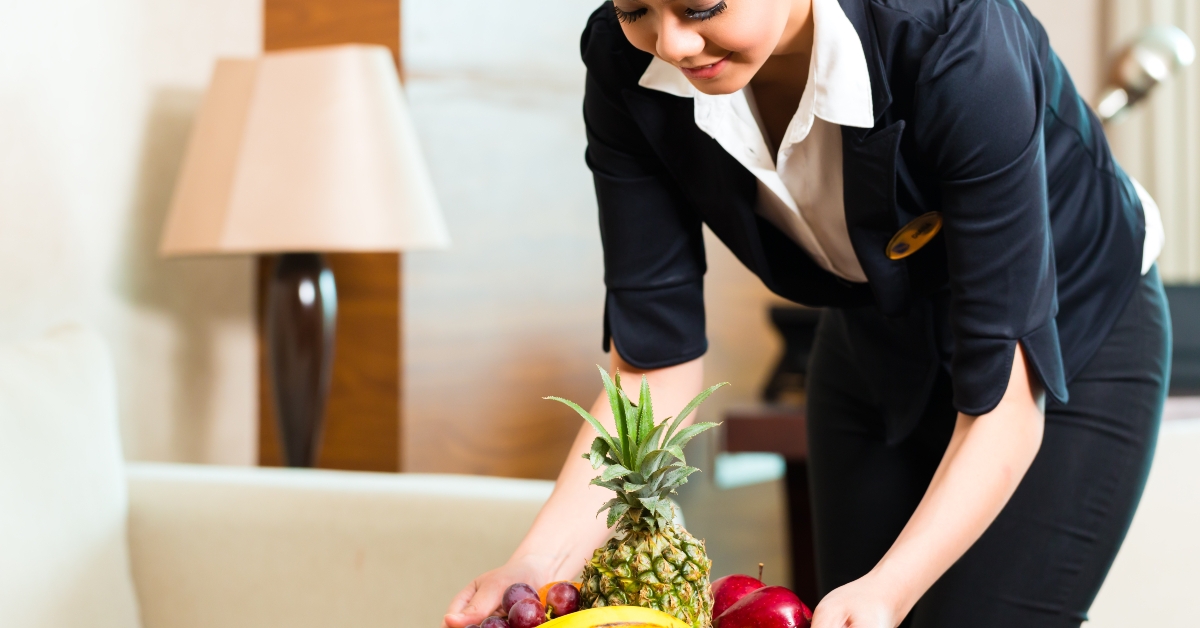 Chinese hotel housekeeper placing fruit