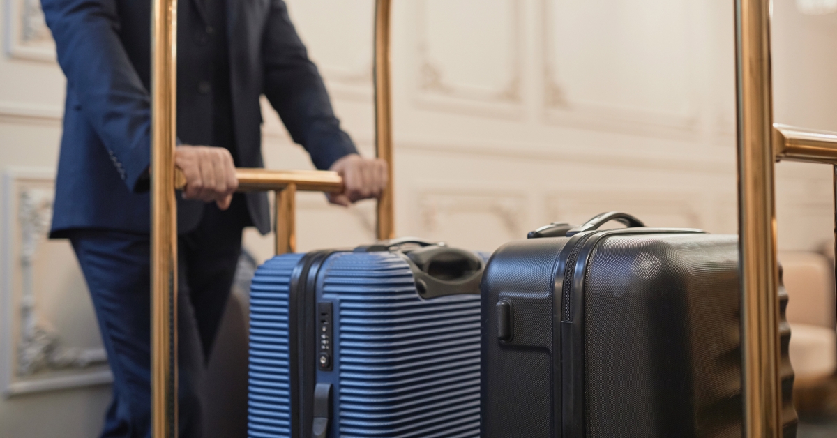 Male porter wearing suit pushing cart