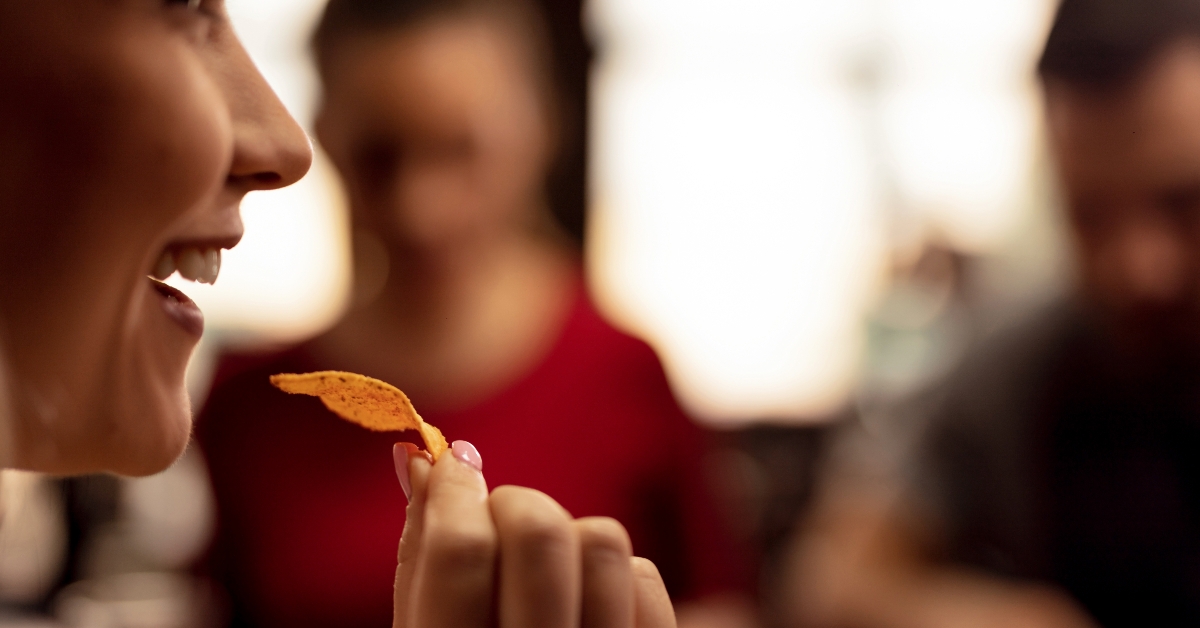 happy woman eating nacho chips