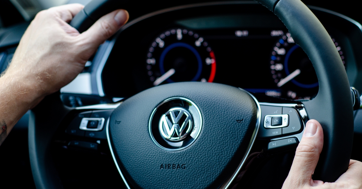 hands of driver on steering wheel of car