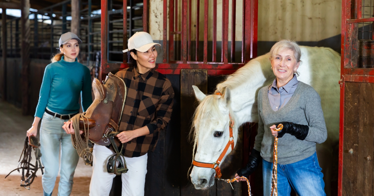 asian horsewoman holding saddle