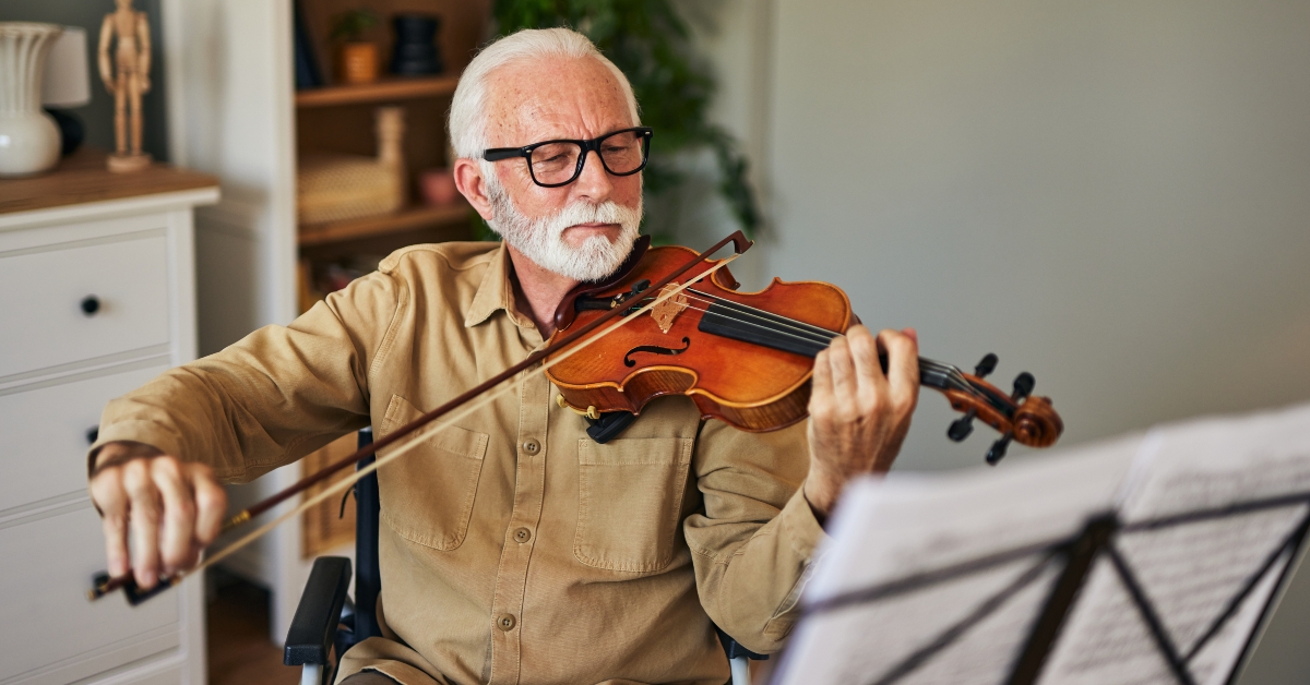 elderly man in the wheelchair playing violin