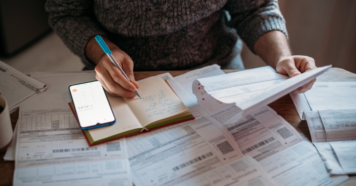 hands with a calculator and utility bills