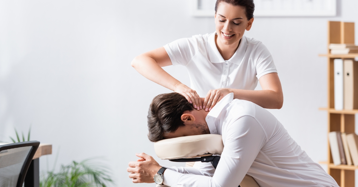female masseuse doing neck massage for businessman