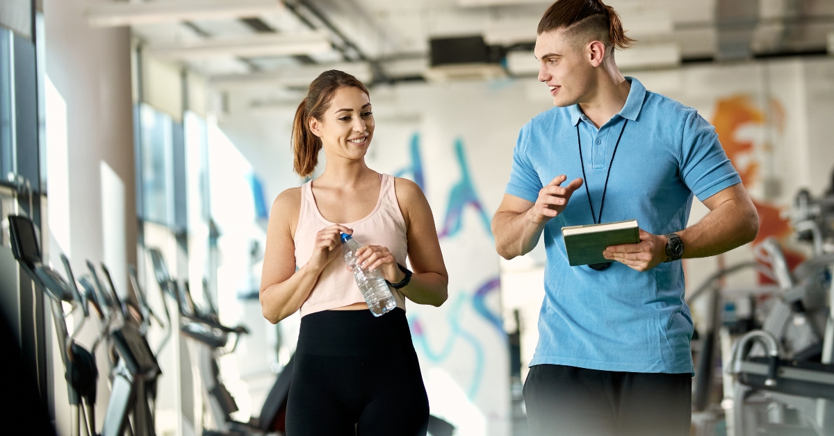 fitness instructor and woman at gym