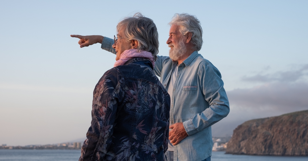 senior couple standing at sunset