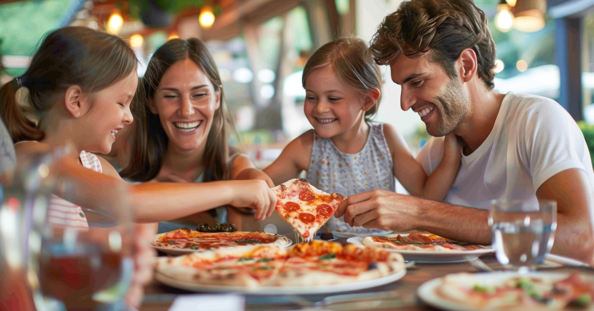 happy family eating pizza at restaurant