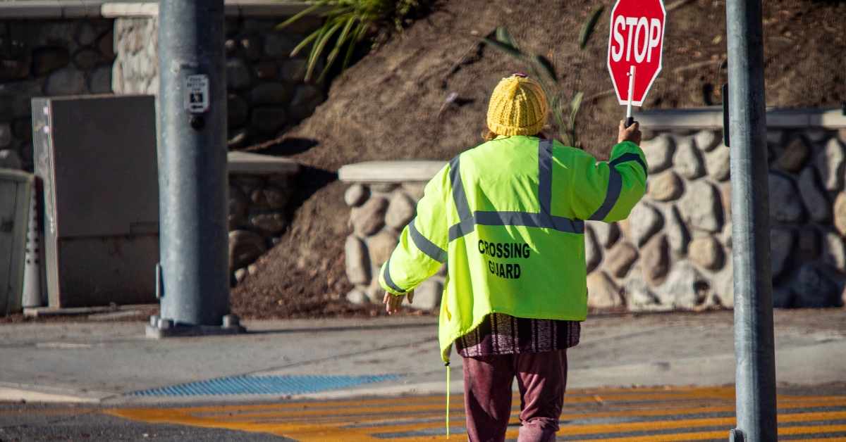 A school crossing guard holding a red stop sign