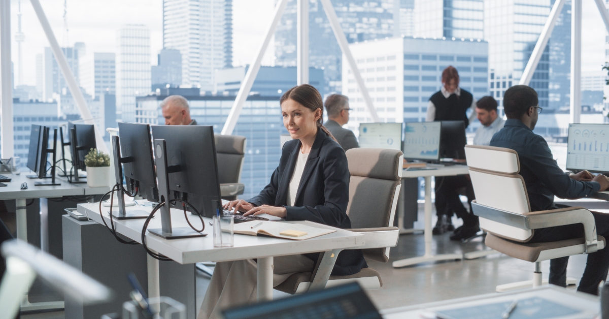 Female Data Analyst Typing On Desktop Computer