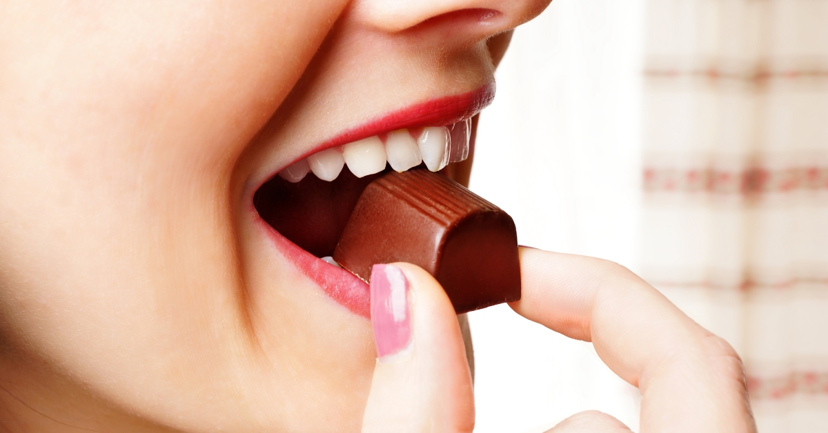 close up look of woman eating chocolate
