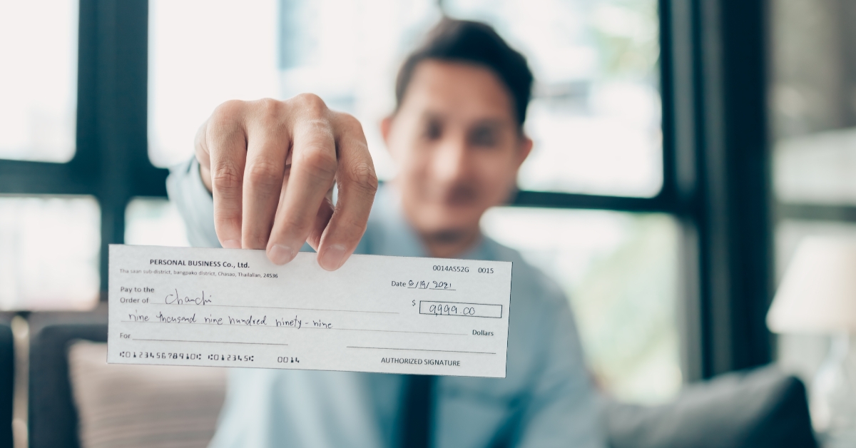 Businessperson's hand giving cheque