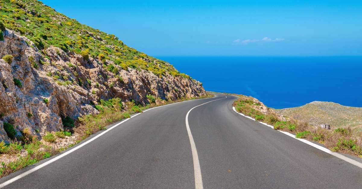 curvy asphalt road leading to amazing sea