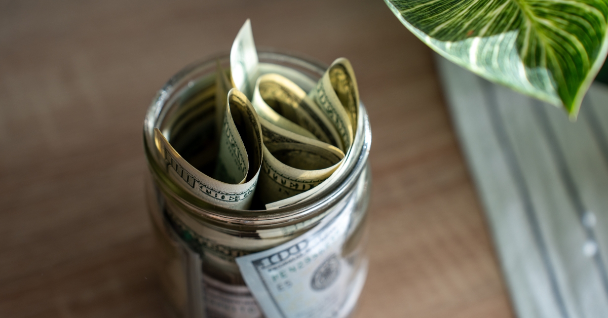 Glass jar filled with rolled US dollar bills