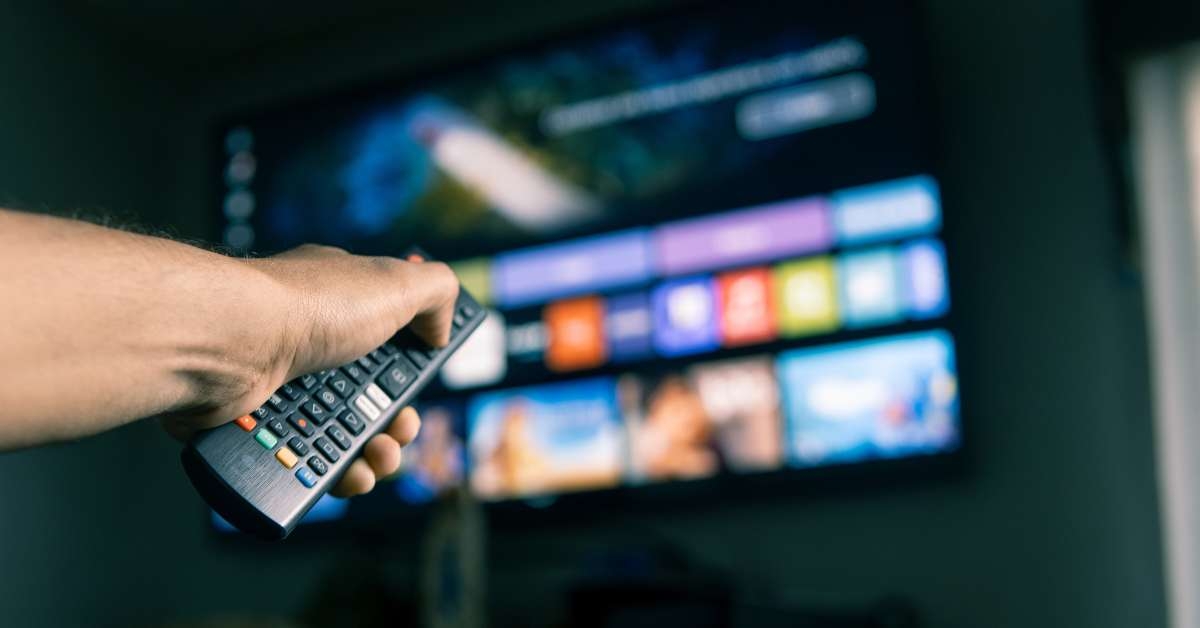 man using remote control to choose streaming platform