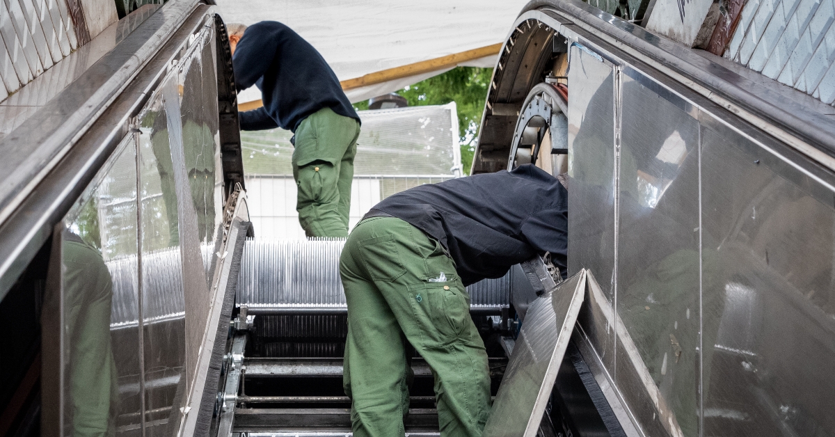 technicians fixing escalator