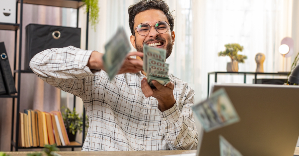 businessman working on laptop and wasting throwing money cash