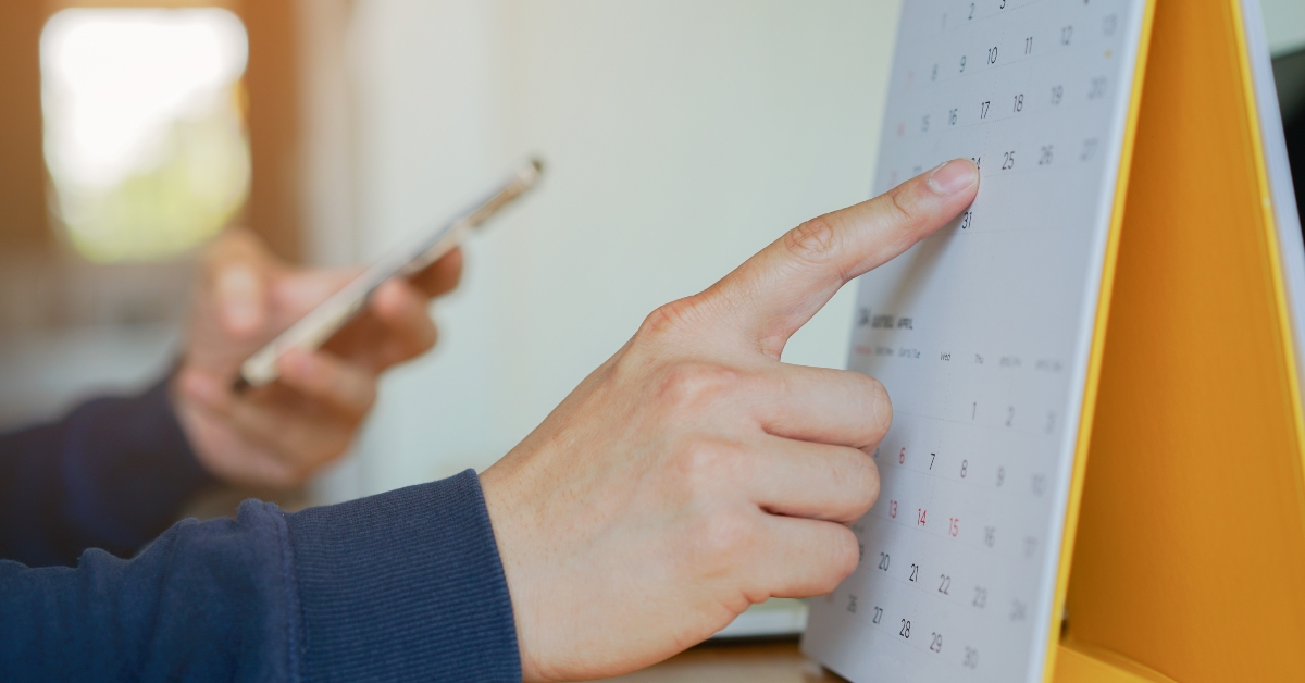 businessman writing schedule on calendar