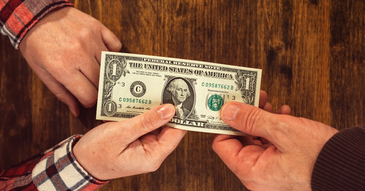 Woman offering one dollar bill to man