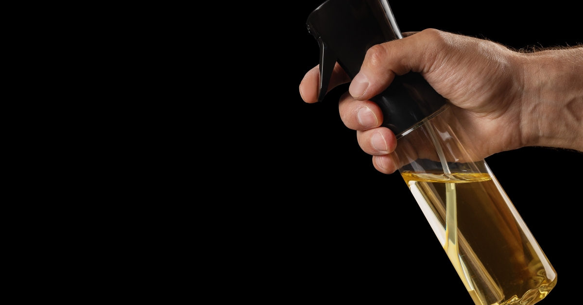 Olive oil spray dispenser in the hand