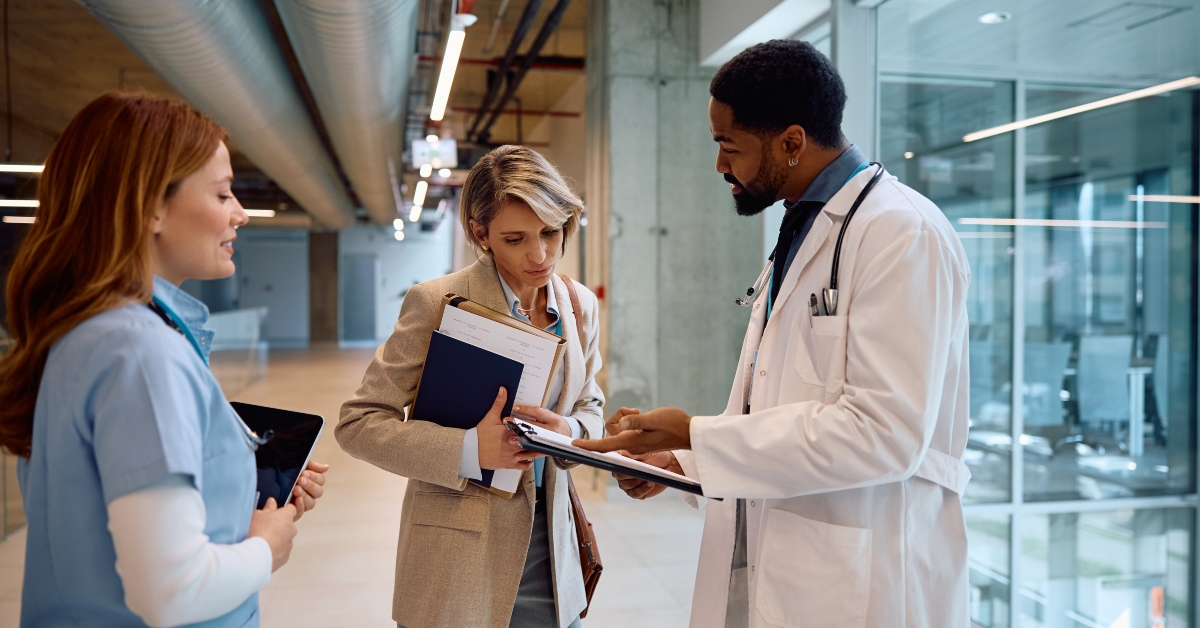 Hospital administrator analyzing reports with doctors