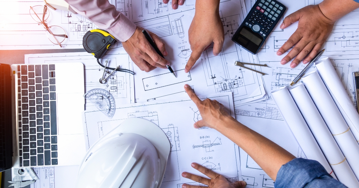 engineers pointing to building on blueprint